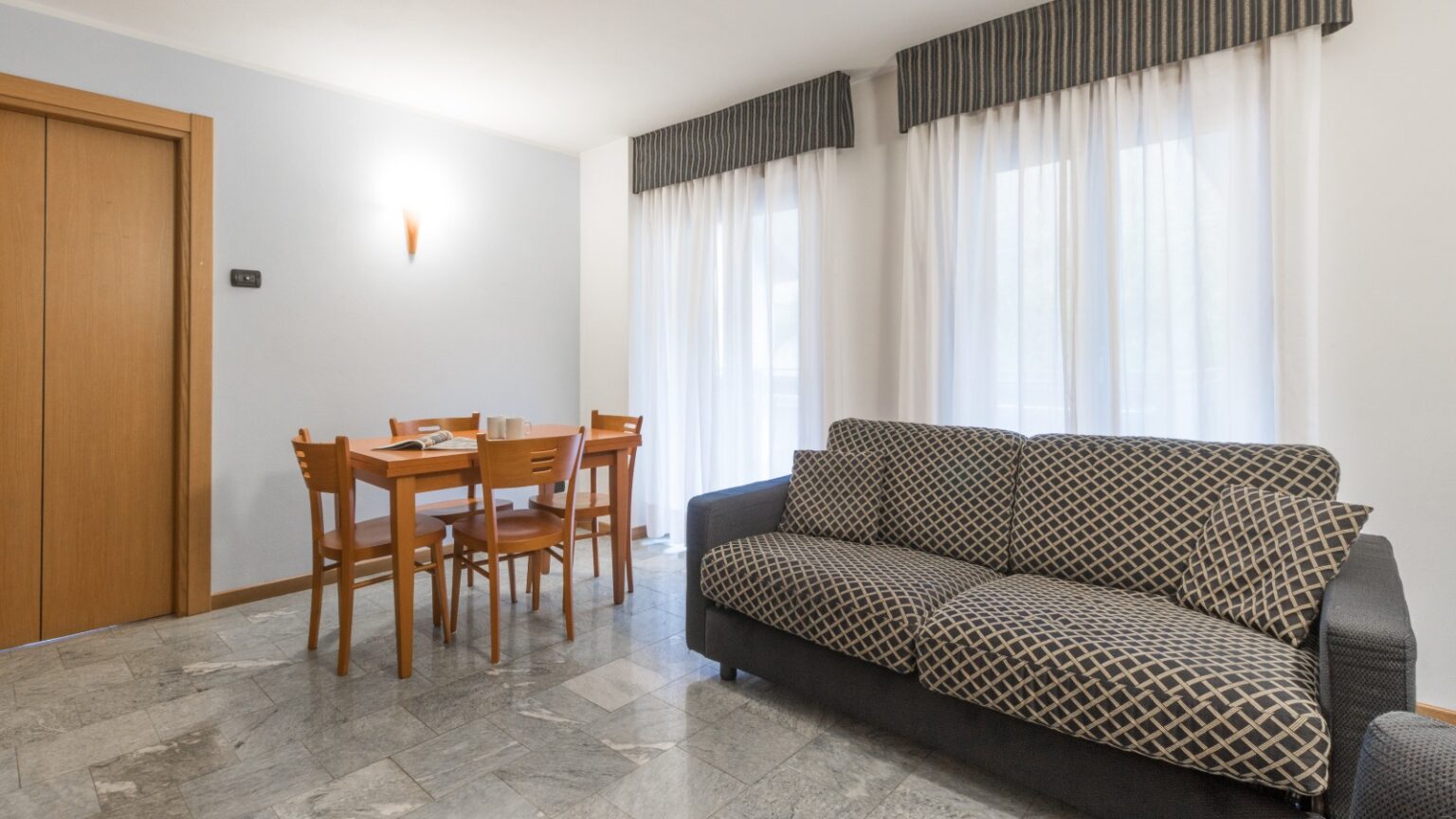 soggiorno con divano e tavolo in appartamento trilocale in in Valmalenco